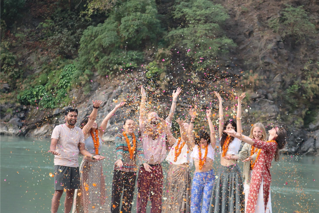 Students celebrating with flower petals on the banks of the Ganges