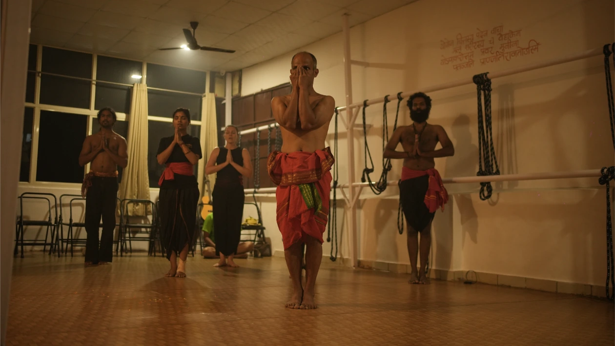 Students and teachers in traditional attire during an evening ceremony