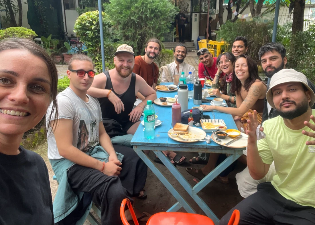 Students and teachers gathered around an outdoor breakfast table